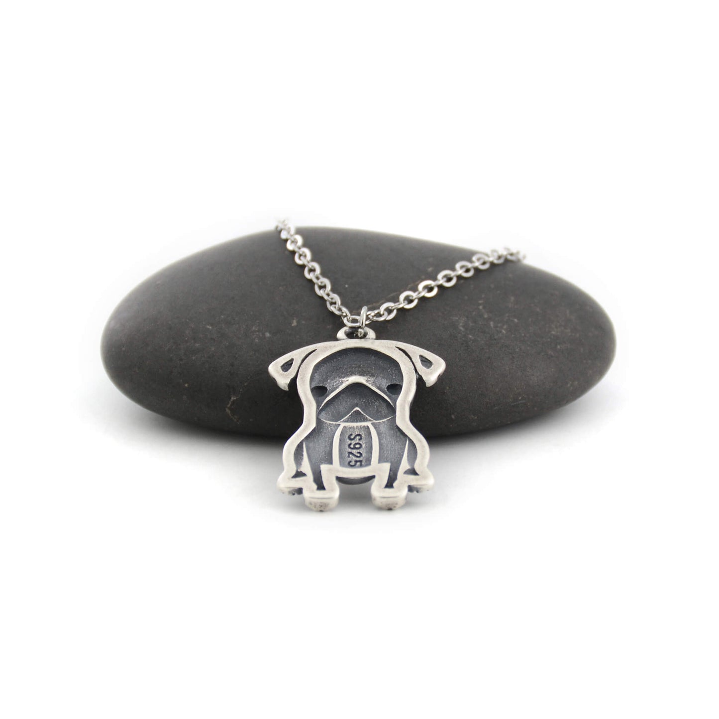 back view of pug silver charm displayed on black pebble