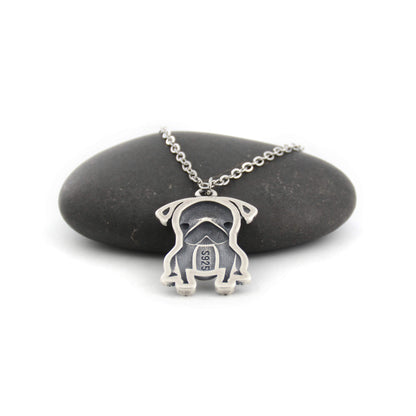 back view of pug silver charm displayed on black pebble