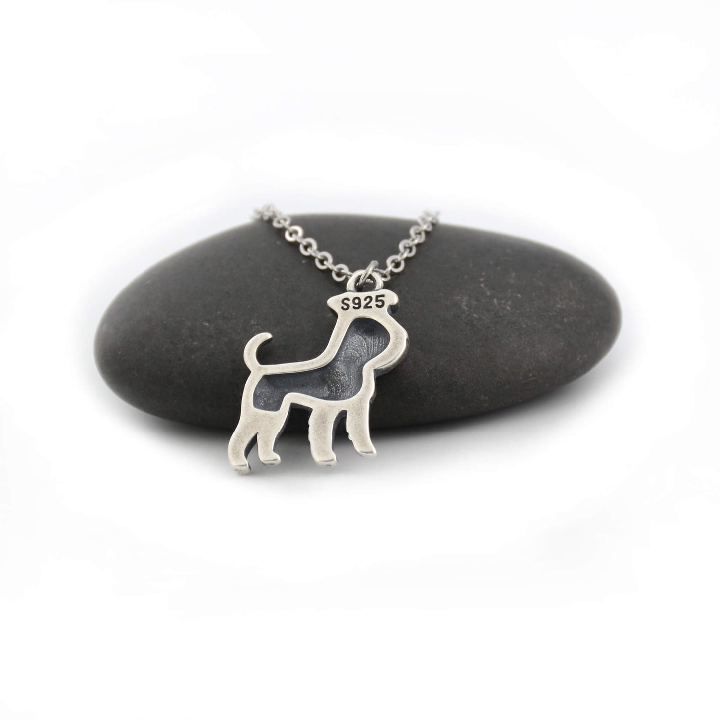 back view of silver schnauzer charm displayed on black pebble