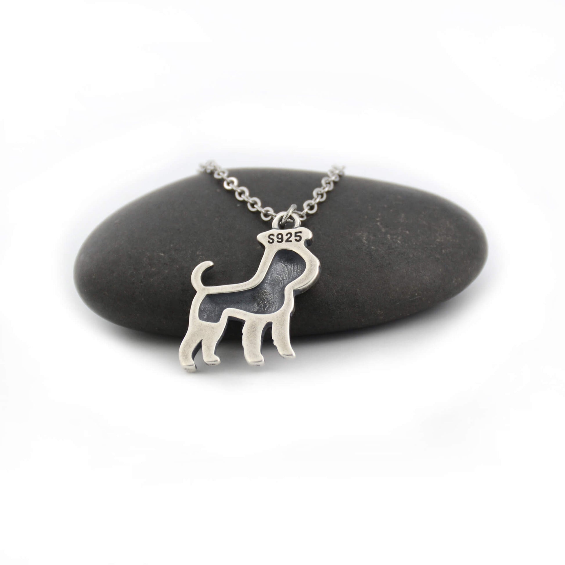back view of silver schnauzer charm displayed on black pebble