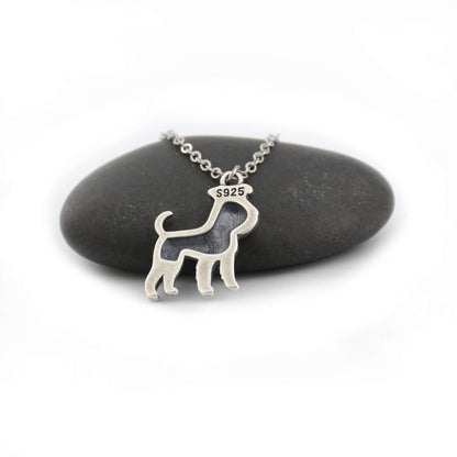 back view of silver schnauzer charm displayed on black pebble