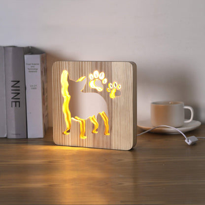 French Bulldog LED night light switched on, on a desk beside books and a mug