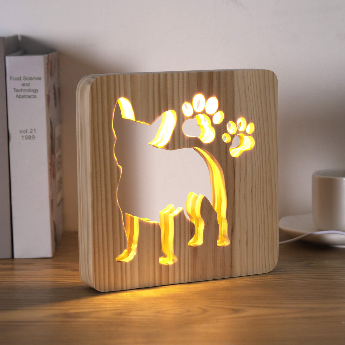 Frenchie wooden lamp glowing on a desk, viewed from a slight angle