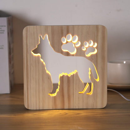 German Shepherd LED night light switched on, on a desk beside books and a mug