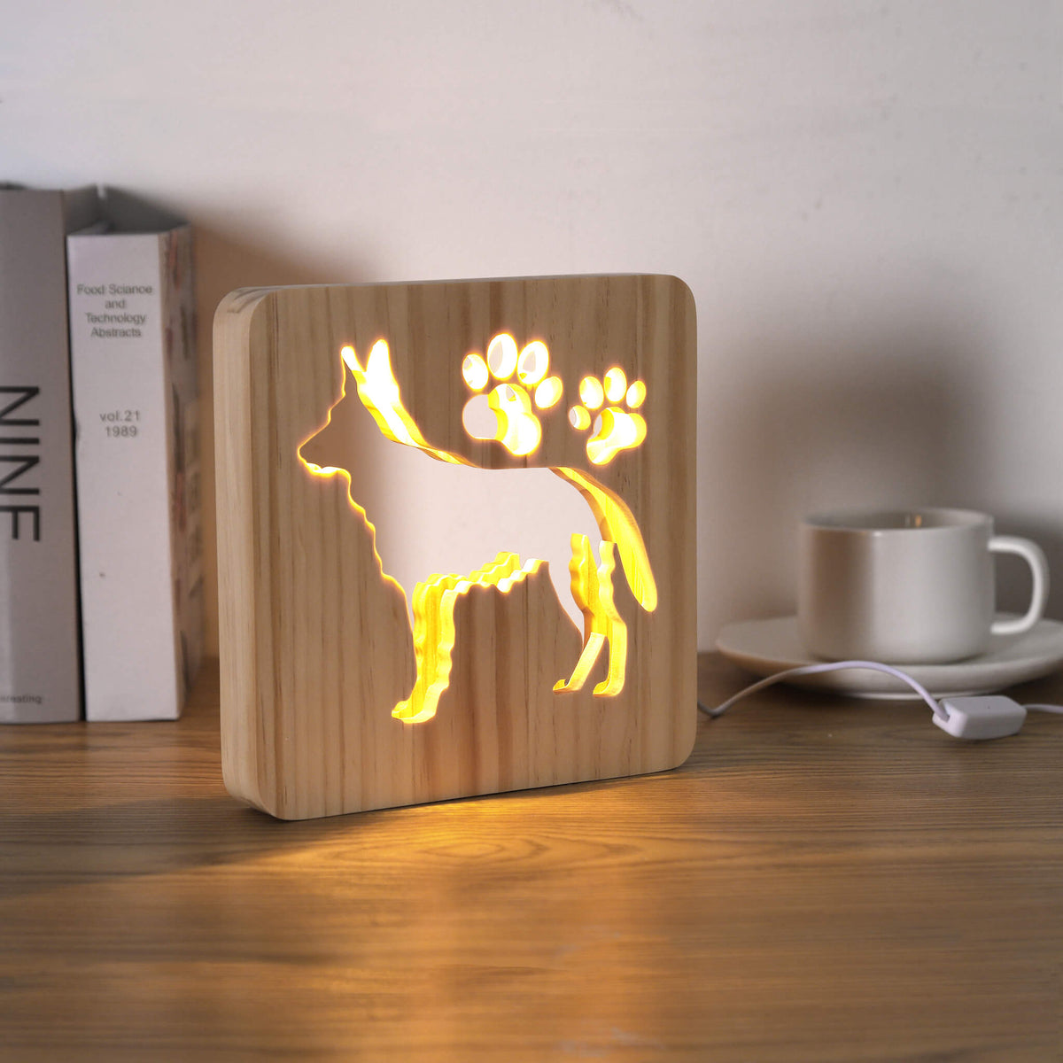 Lit German Shepherd USB night light on a desk next to books