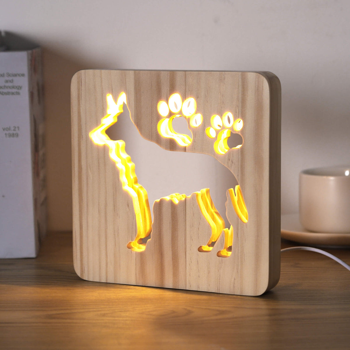 Alsatian wooden lamp glowing on a desk, viewed from a slight angle