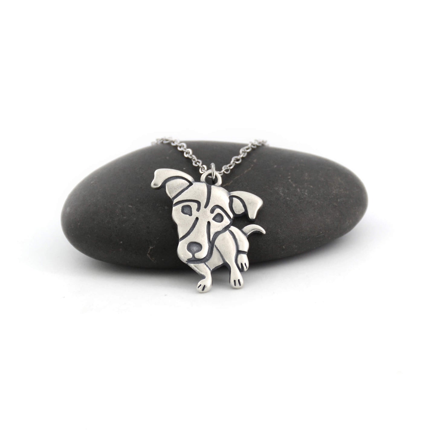 Jack Russell silver charm displayed on black pebble
