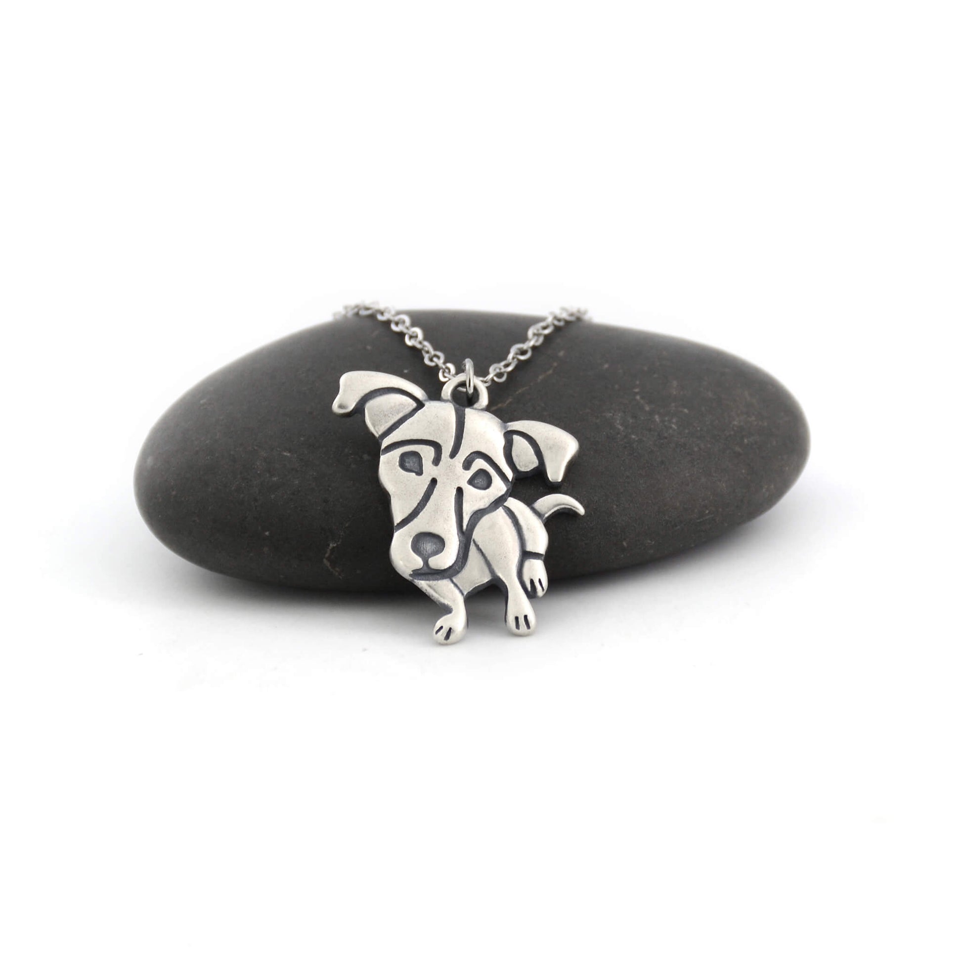 Jack Russell silver charm displayed on black pebble