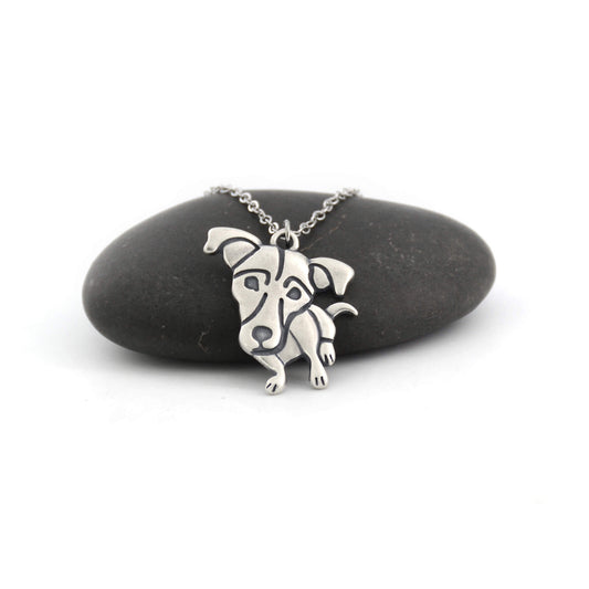 Jack Russell silver charm displayed on black pebble