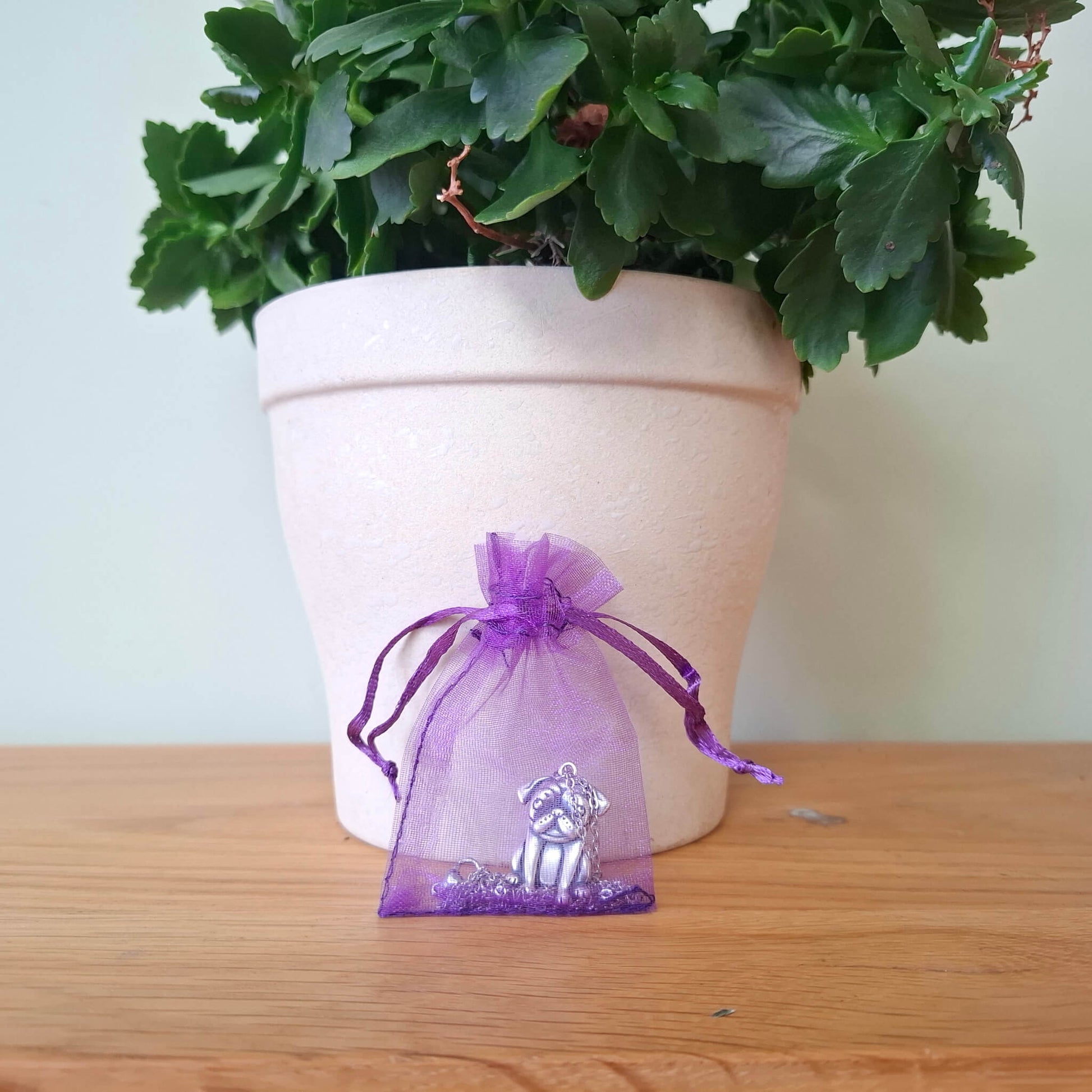 pug charm necklace in purple organa bag