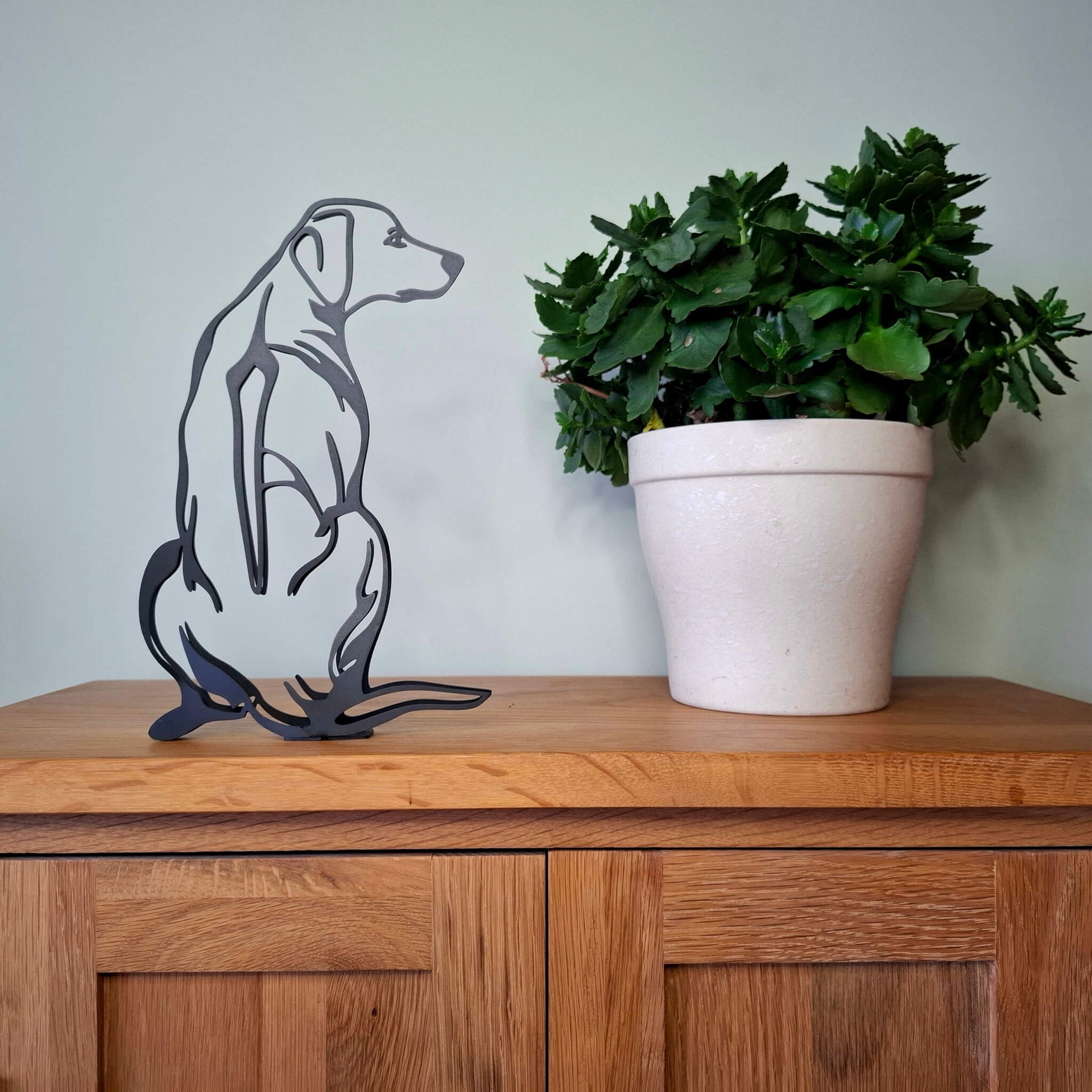 black rhodesian ridgeback statue sitting on a wooden surface