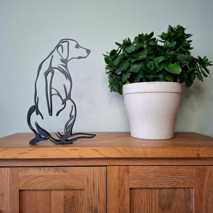 black rhodesian ridgeback statue sitting on a wooden surface