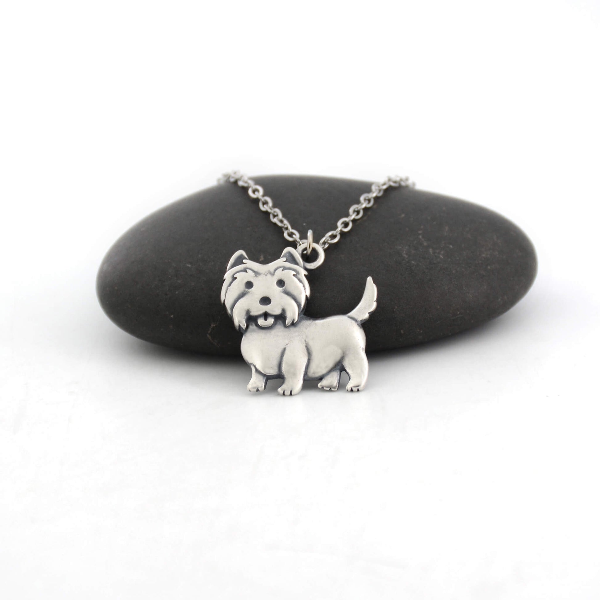 west highland terrier silver charm displayed on black pebble