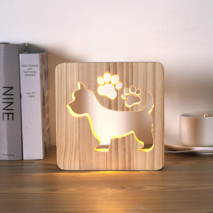 Westie LED night light switched on, on a desk beside books and a mug