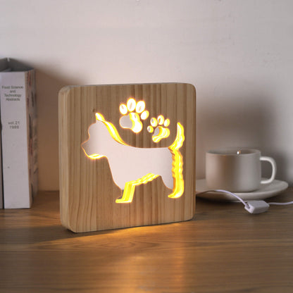 Lit West Highland Terrier night light on a desk next to books
